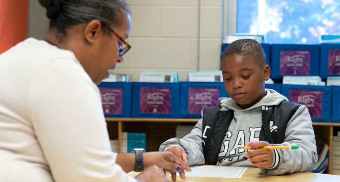 A teacher helps a student.