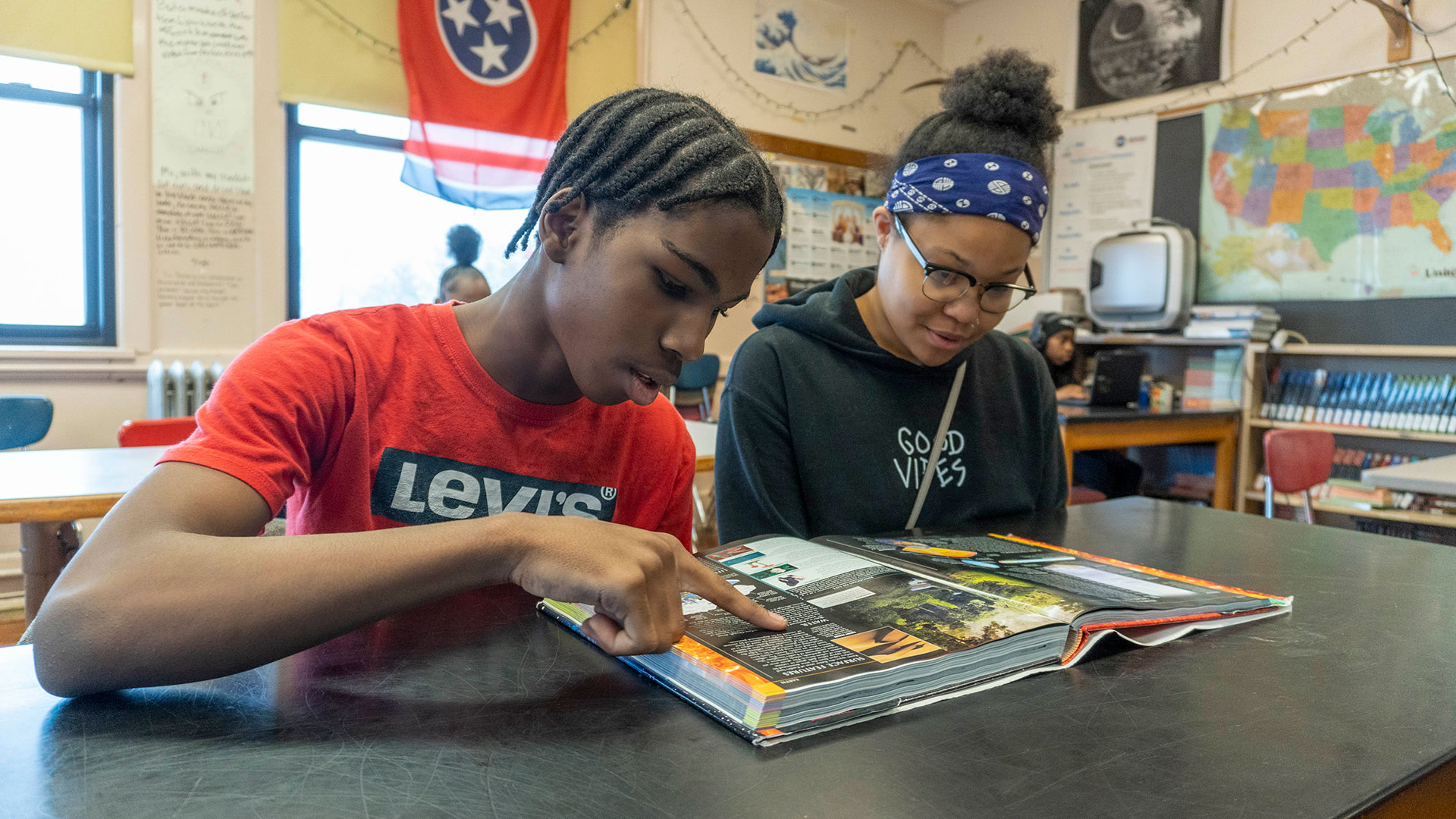 Two students looking at a book.