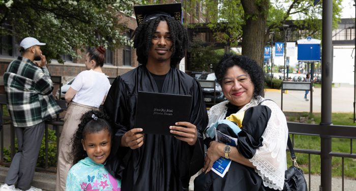 A graduate outside with their family.