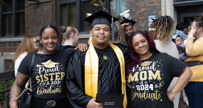 A graduate outside with their family.