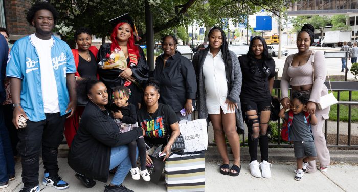 A graduate outside with their family.