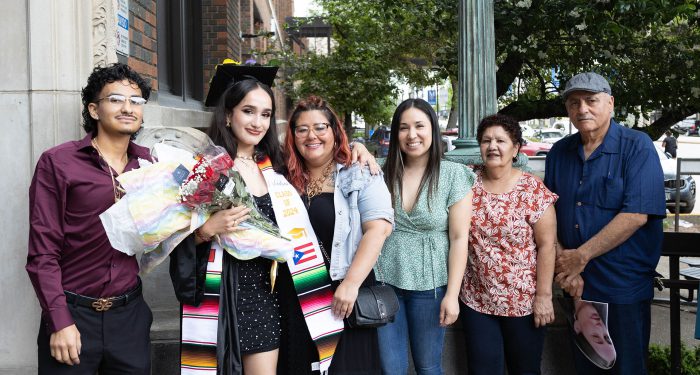 A graduate outside with their family.