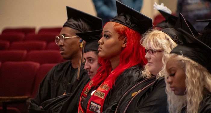 Graduates sitting in a row.