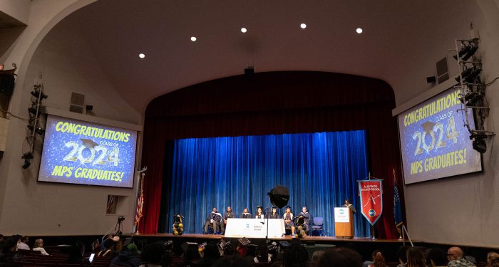 A stage with screens that read "Congratulations Class of 2024 MPS Graduates!"