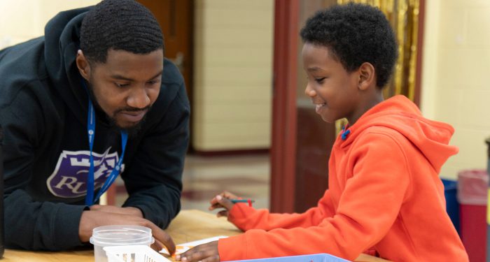 A teacher helping a young student.