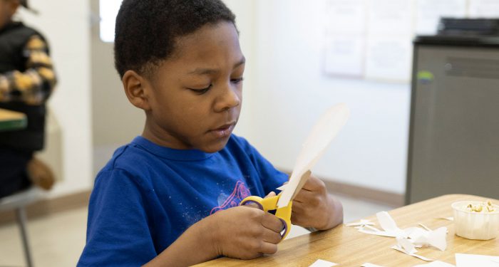 A young child cutting paper.
