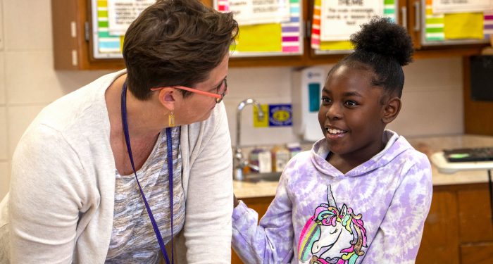 A child smiles at her teacher.