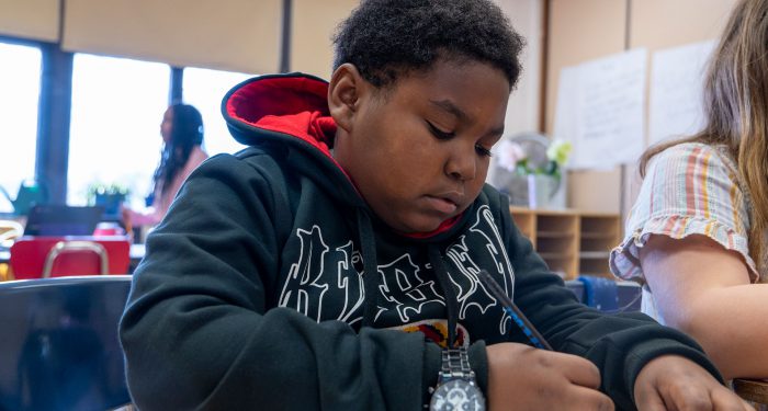 A child in a classroom writing.
