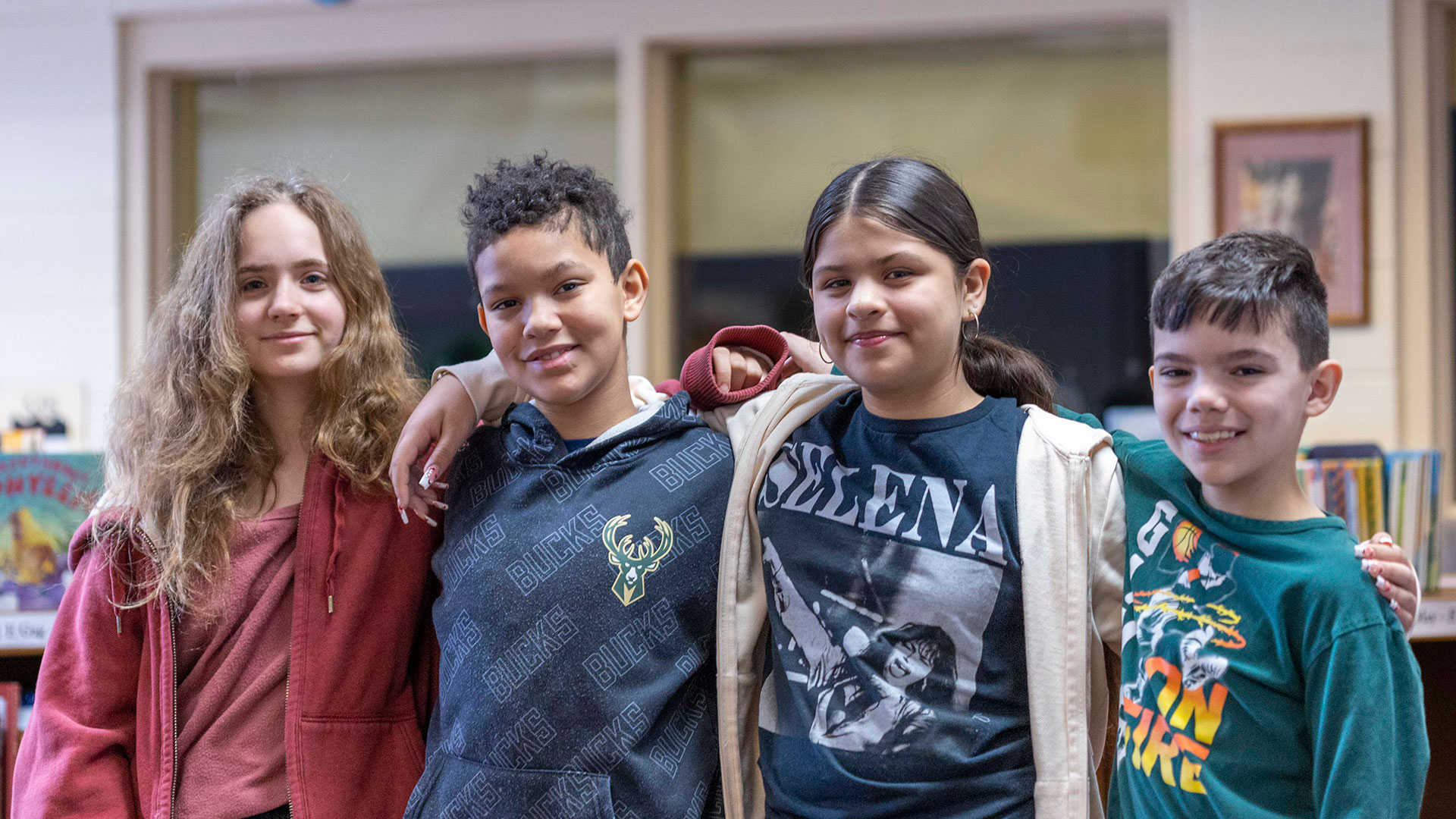 Four students with their arms around one another.