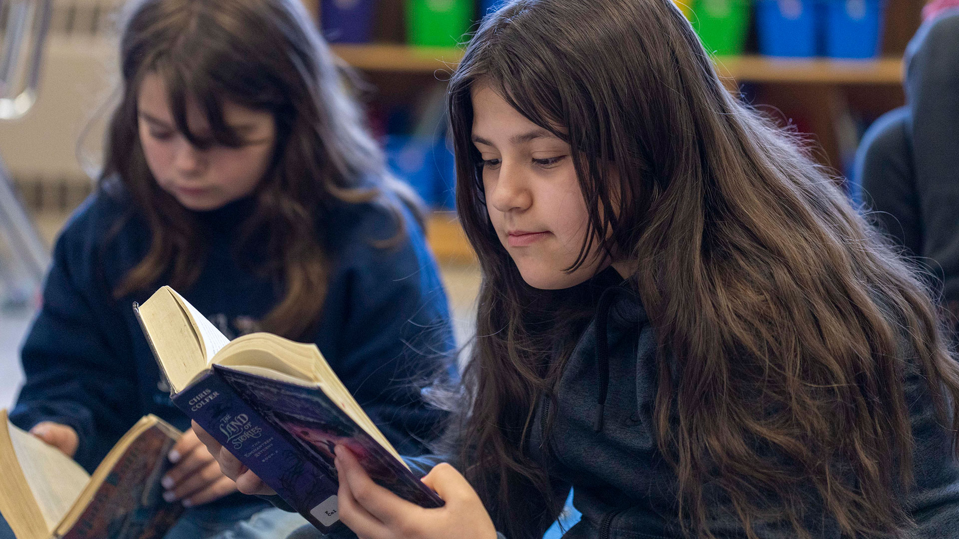 Two girls reading books.