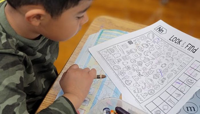 A young boy does a Look & Find sheet