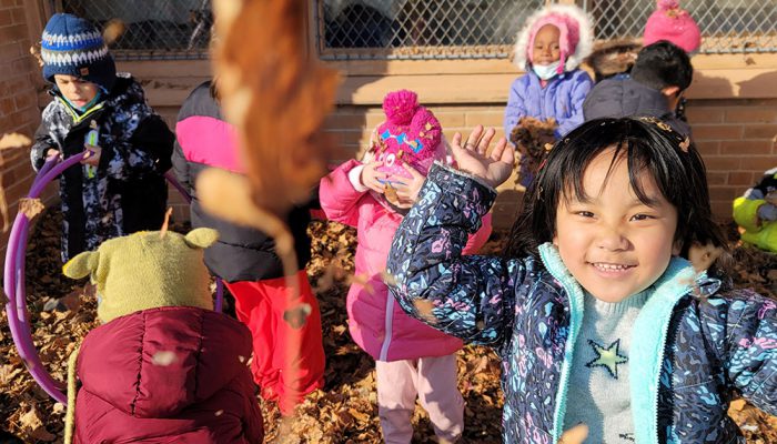 Kids playing in fall leaves