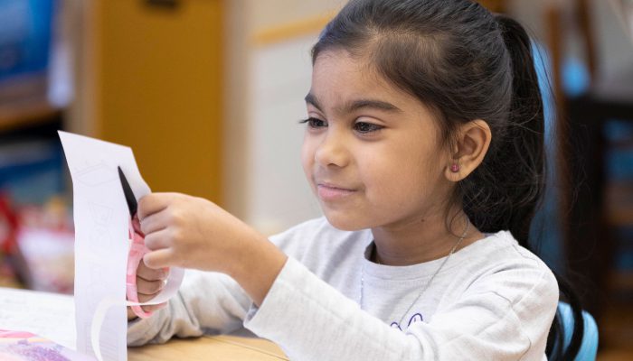 A young girl cutting paper.