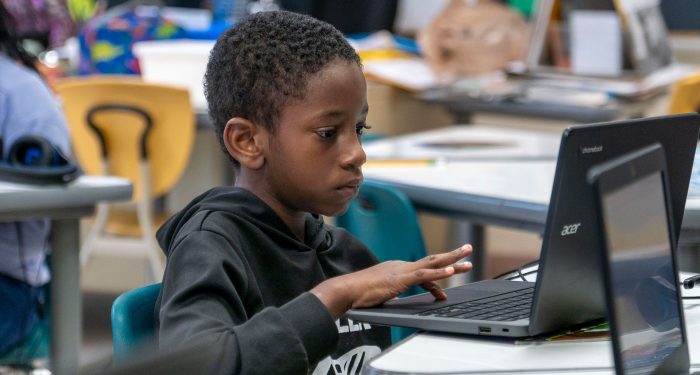 A young child using a laptop.