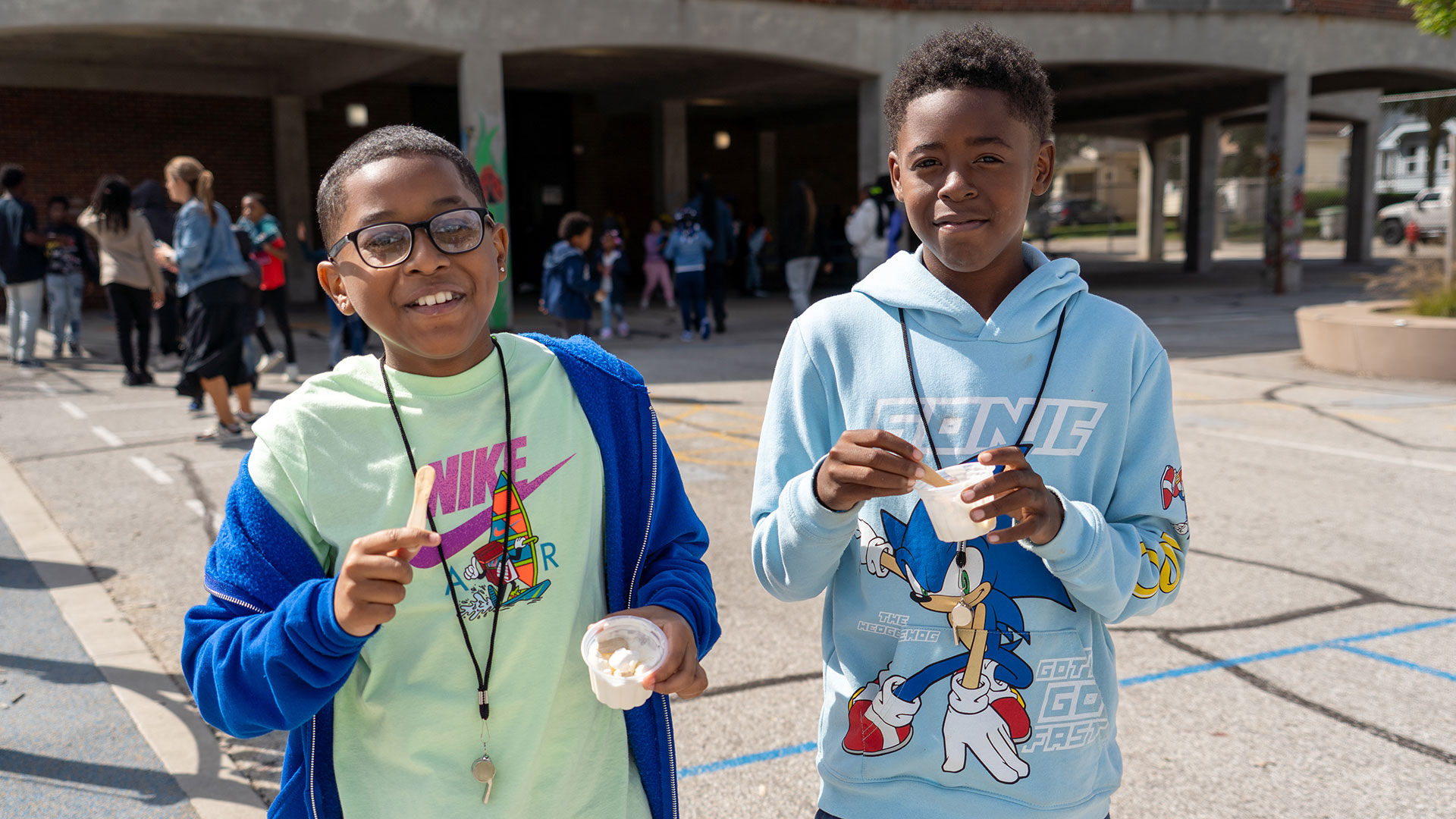 Smiling boys on a playground with icecream.