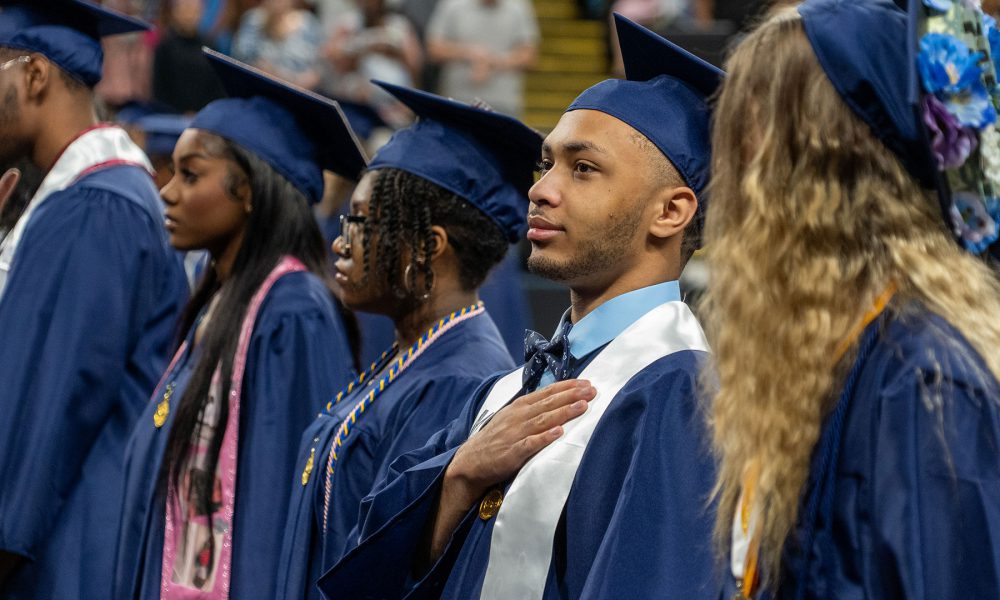 Graduates standing for the Pledge of Allegiance.