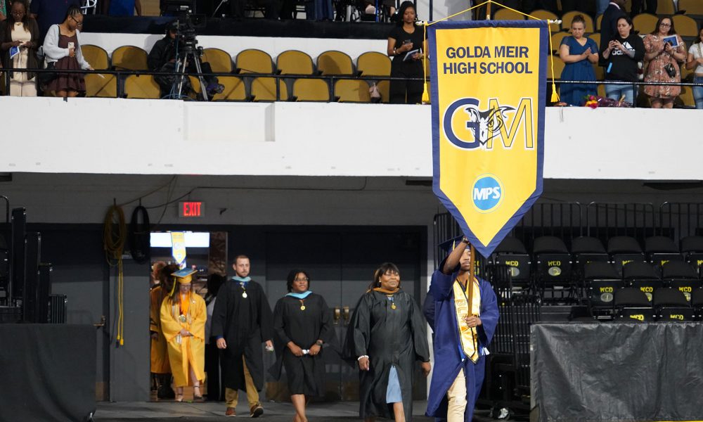 Graduates and staff enter the arena.