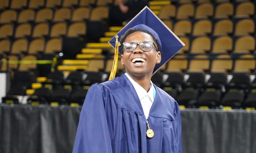 A graduate smiles while entering the ceremony.