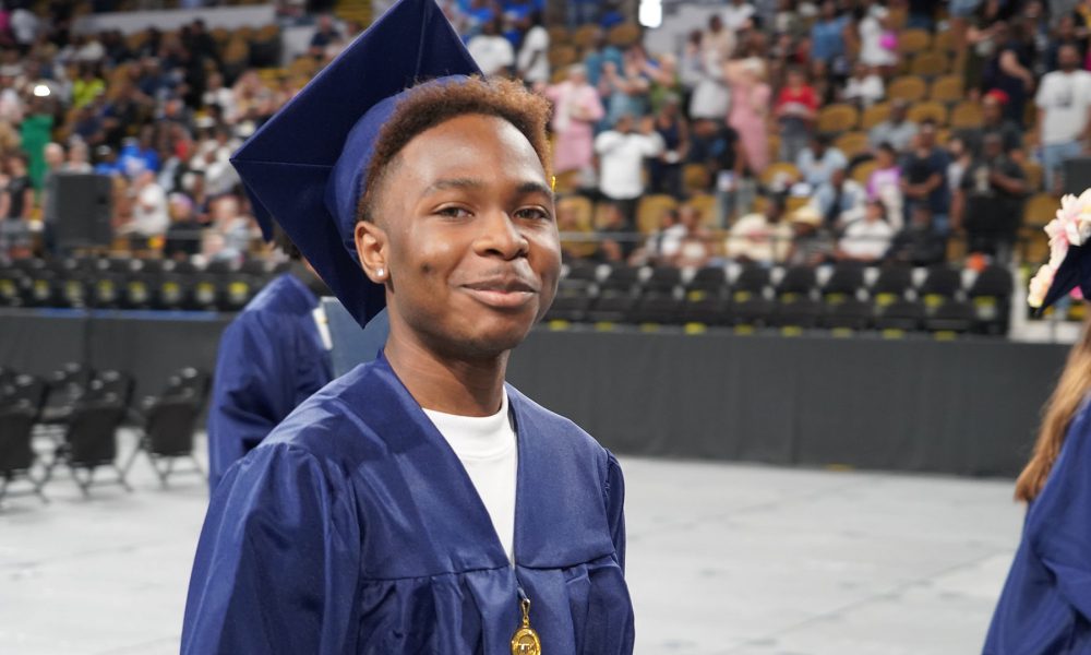 Graduates smiling as they leave the ceremony.