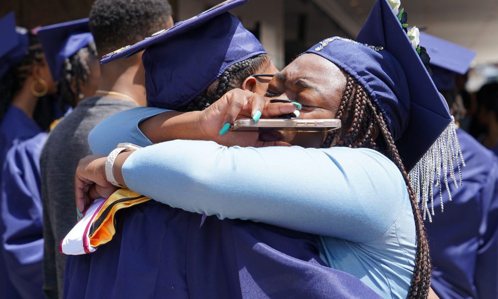 Graduates hugging.