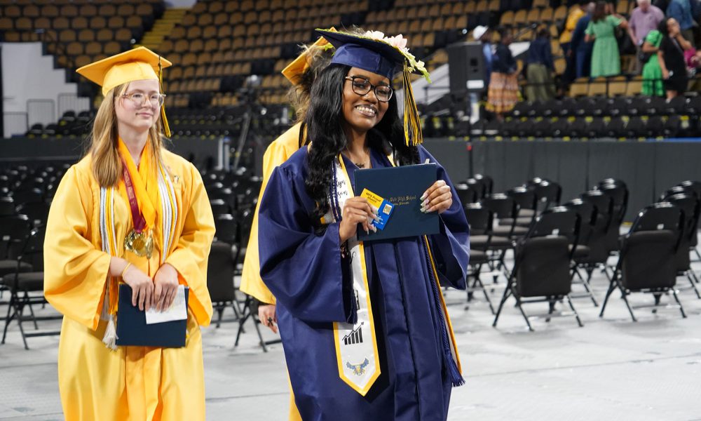 Graduates smiling as they leave the ceremony.