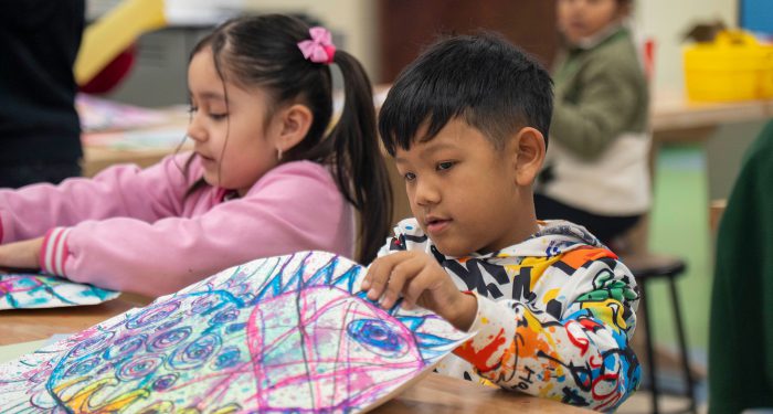 Children make colorful paper projects.