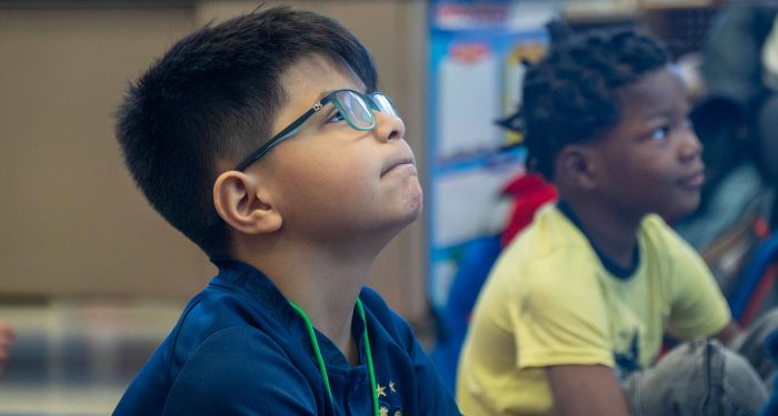 Children in a classroom paying attention.