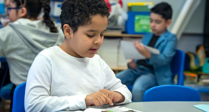Children in a classroom reading.