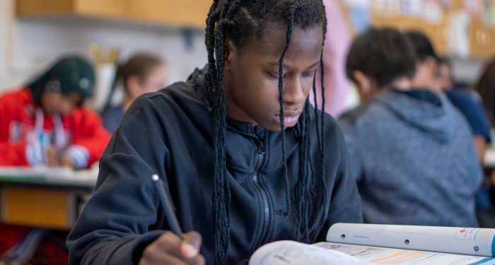 A middle schooler reading a textbook.