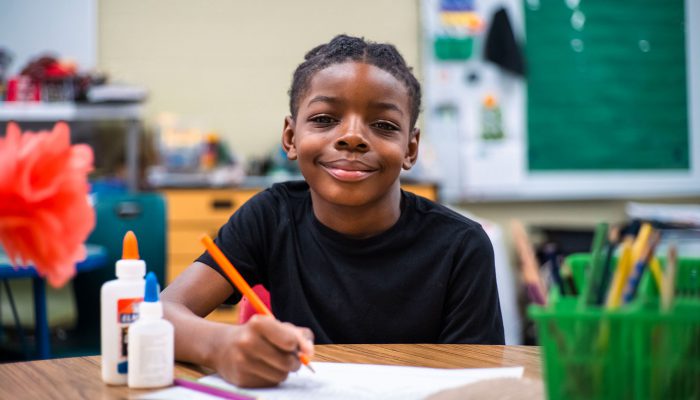 A student at a table writing.