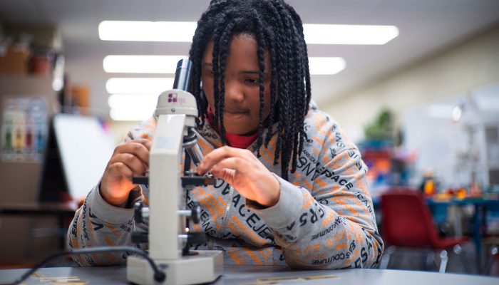 A child using a microscope.