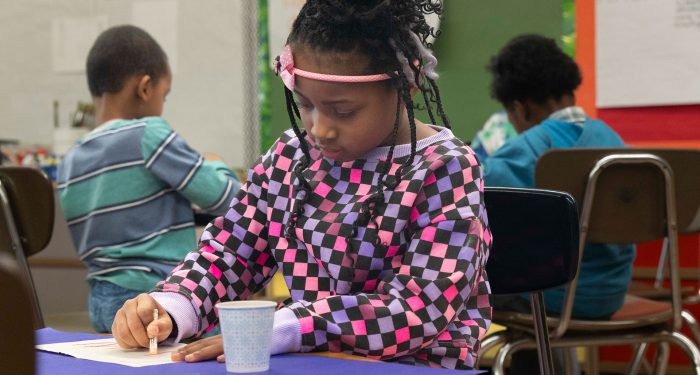 A young girl coloring.