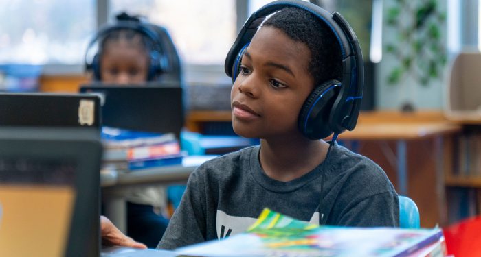 A student with headphones using a computer.