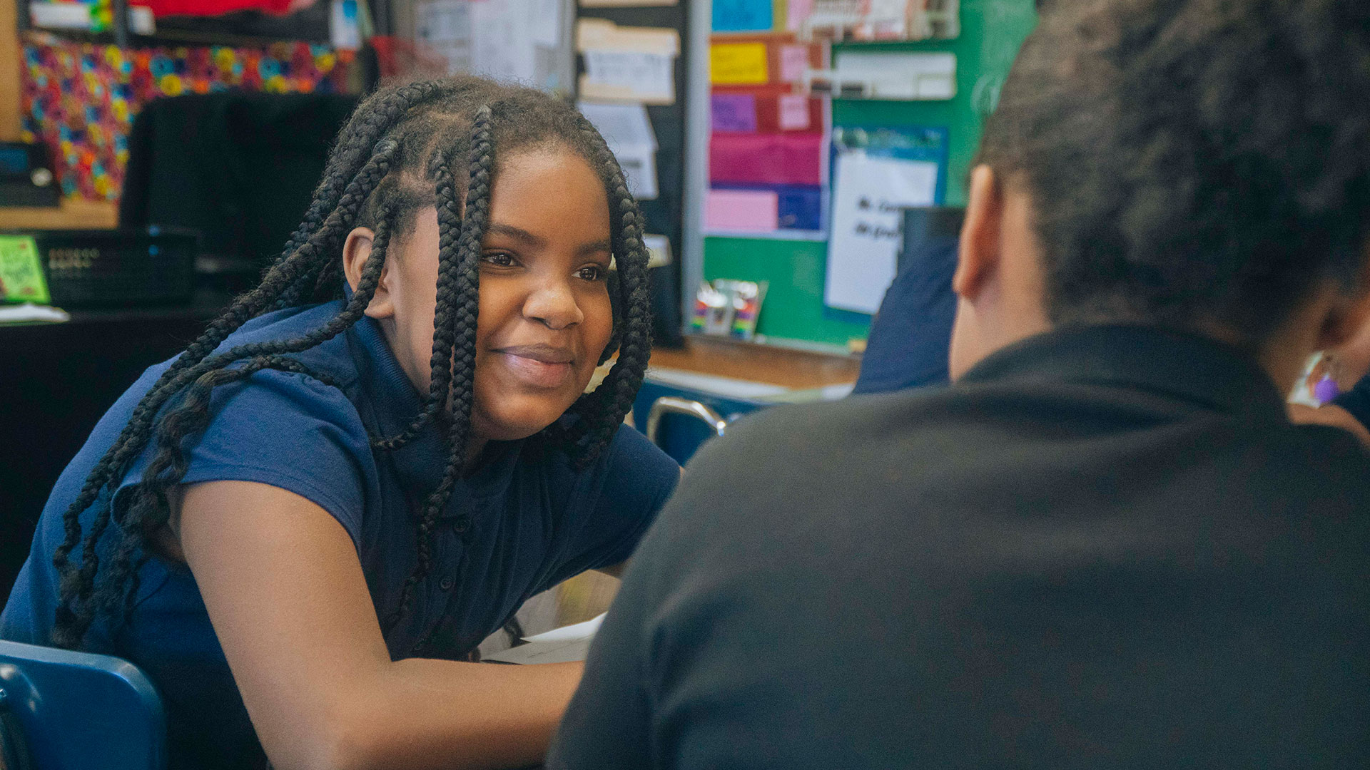 A smiling child in a classroom.