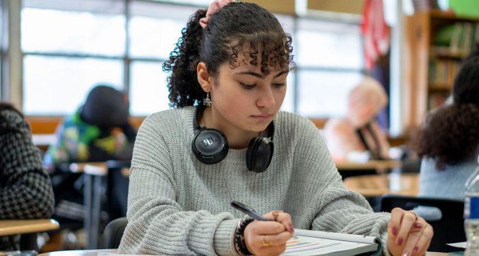 A student writing in a workbook.