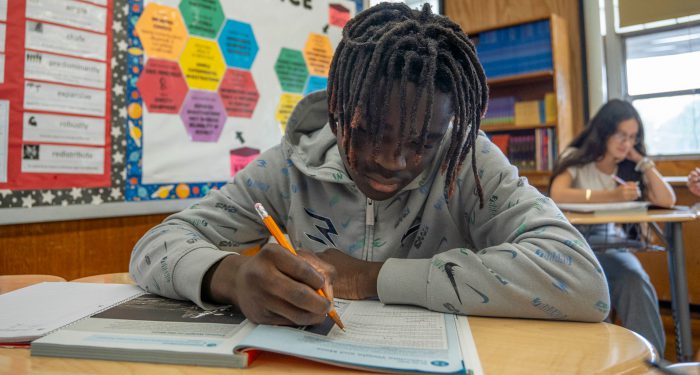 A boy at a desk working on an assignment.