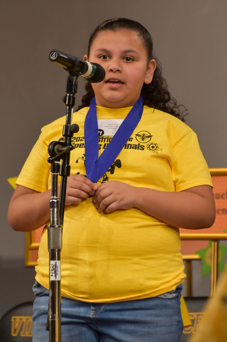 Sophia spelling out a word at the microphone.