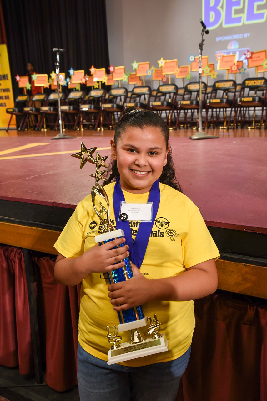Sophia with her trophy in front of the stage.