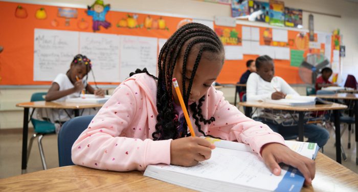 Students it their desks working on an assignment.