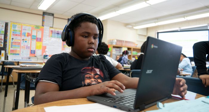 A student at a desk using a computer.