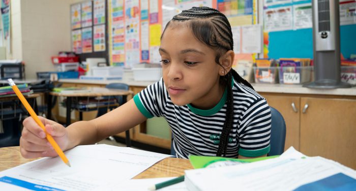 A child in a classroom works on an assignment.
