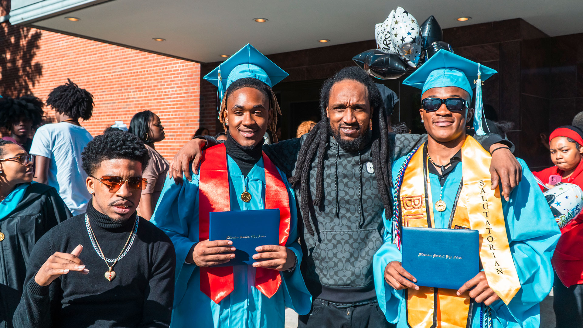 Graduates celebrate outside after the ceremony with their families.