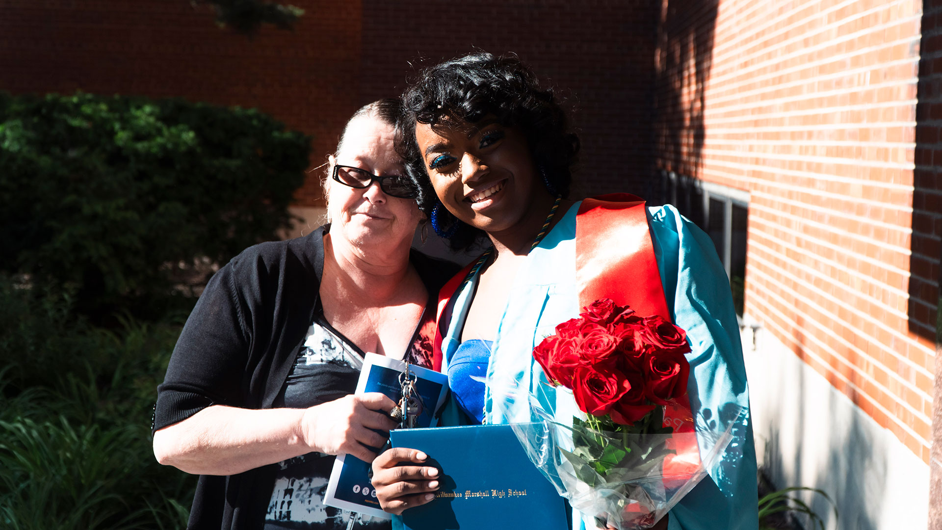 Graduates celebrate outside after the ceremony with their families.