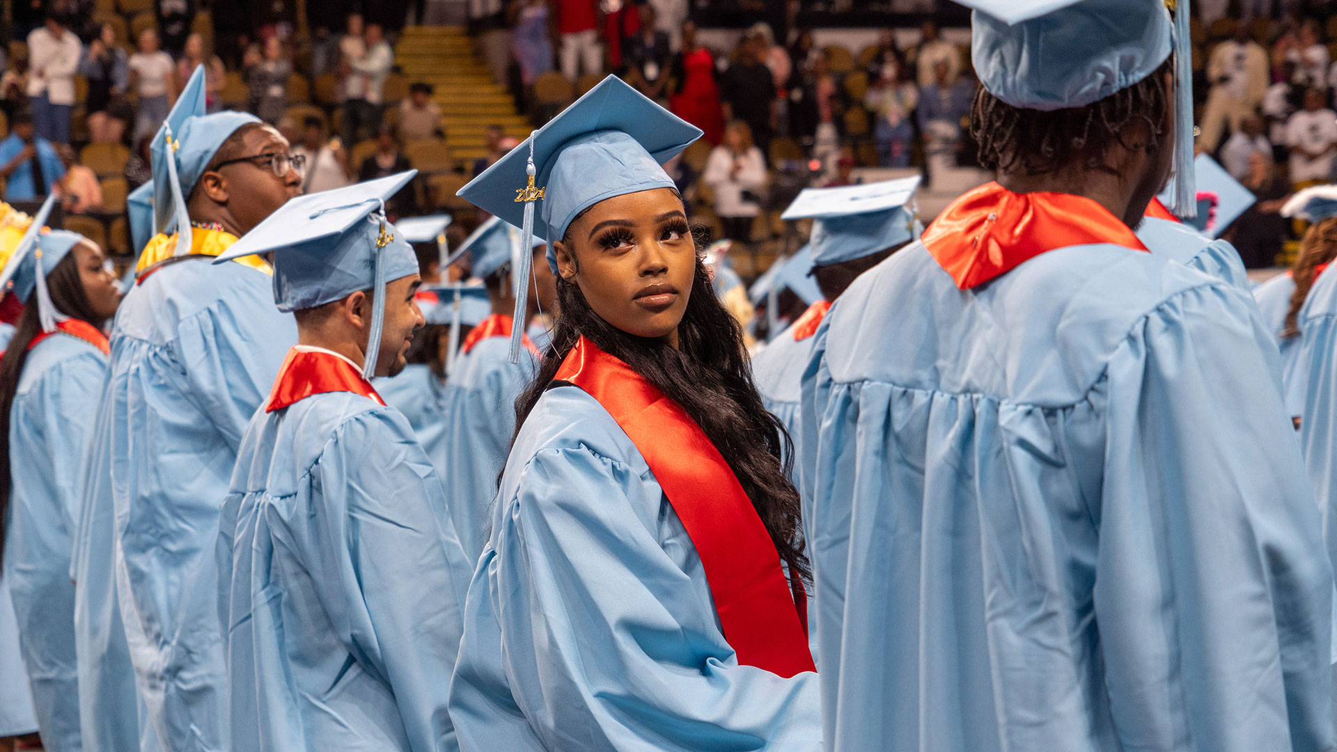 A graduate looks into the crowd.