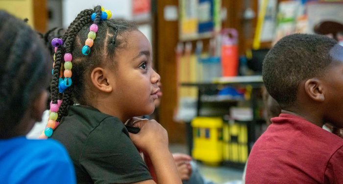 A young child looking up at their teacher.