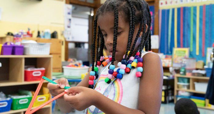 A young girl making a triangle shape.