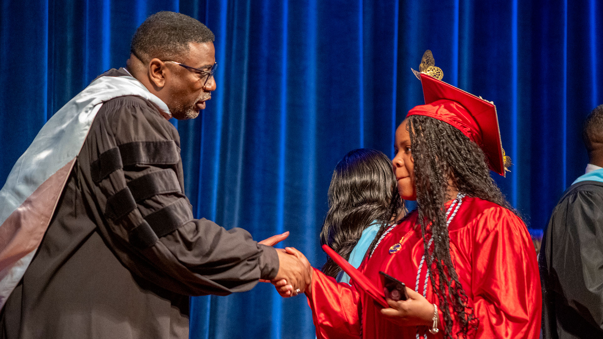 A graduate accepting her diploma.