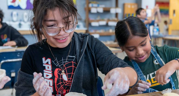 Children in a classroom working with clay.