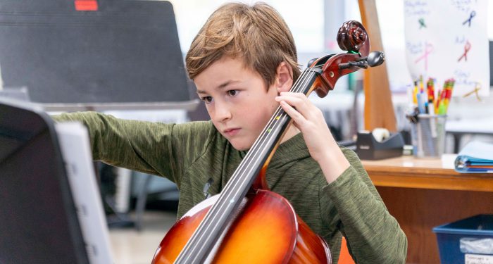 A child plays a cello.