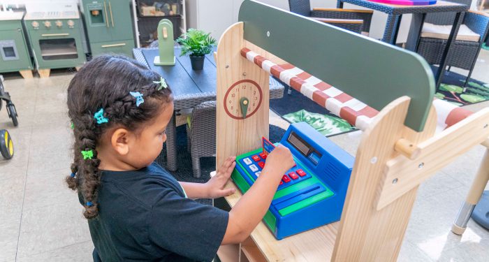 A child playing with a toy cash register.